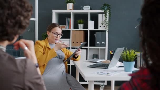 Jeune femme d'affaires enceinte parlant à ses collègues puis ressentant une douleur à l'abdomen touchant le ventre au bureau — Video