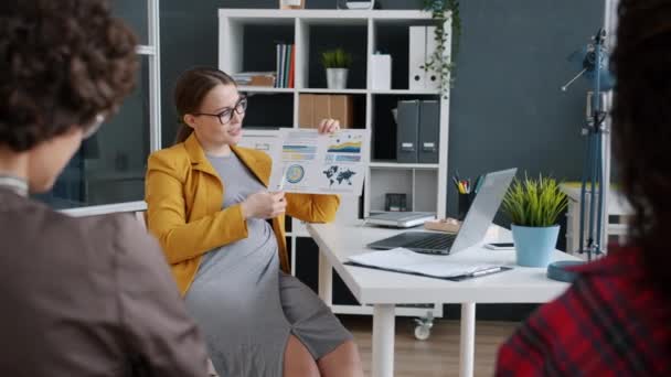 Ambiciosa mujer de negocios embarazada hablando con compañeros de trabajo discutiendo el desarrollo de proyectos en la oficina — Vídeos de Stock