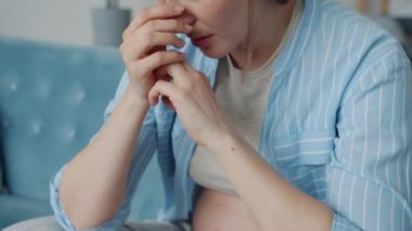 Mutsuz hamile bir kadının evde yalnız başına oturup negatif duygularını dile getirmesi.