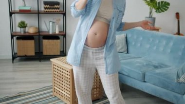 Doğumhanenin gelecekteki annesi dans ediyor ve şarkı söylüyor evde tek başına eğleniyor.