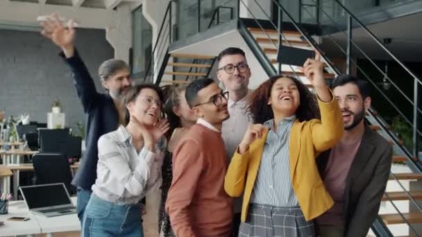 Šťastní mladí muži a ženy, kteří se selfie s kamerou smartphone na pracovišti — Stock video
