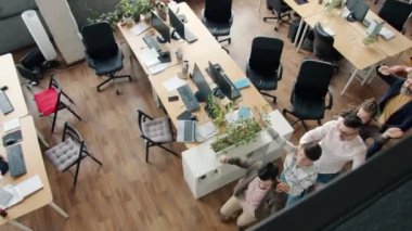 Modern açık alanda dans eden neşeli ofis çalışanlarına yüksek açılı bakış açısı