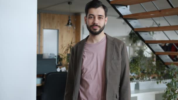 Retrato de chico guapo trabajador de oficina de pie en el trabajo solo mirando a la cámara — Vídeos de Stock