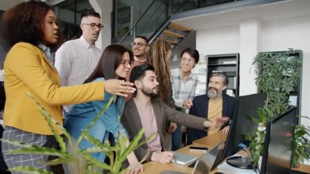 Multi-ethnic team talking brainstorming pointing at computer screen in office — Stock Video