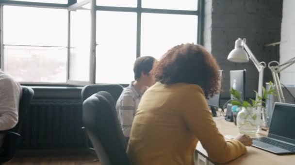Dolly ujęcie wielonarodowej grupy biznesmenów pracujących w biurze otwartego planu przy biurkach — Wideo stockowe