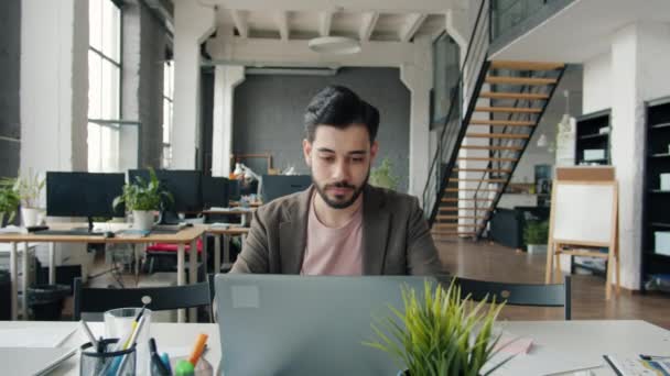 Slow motion of guy using laptop getting good news sharing with colleagues doing high-five clapping hands — Stock Video