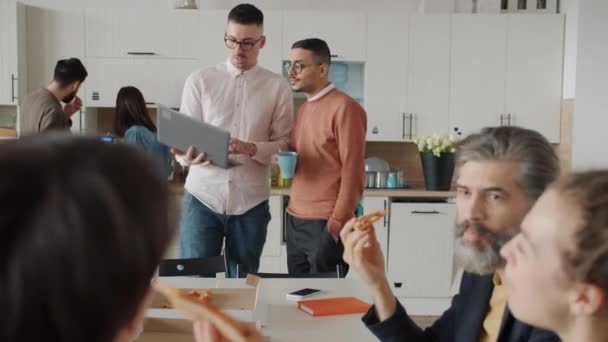 Persone colleghi che parlano mangiare pizza e discutere di lavoro durante la pausa pranzo in ufficio — Video Stock