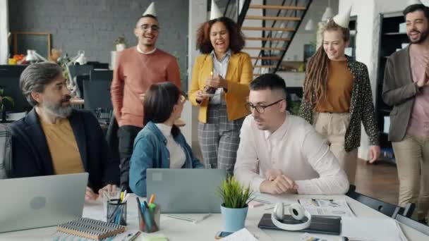 Joyful coworkers congratulating young businesswoman on birthday giving cake making surprise — Stock Video