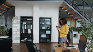 Ofise birlikte çalışan bir grup iş arkadaşı akıllı telefonları kullanarak geliyor.