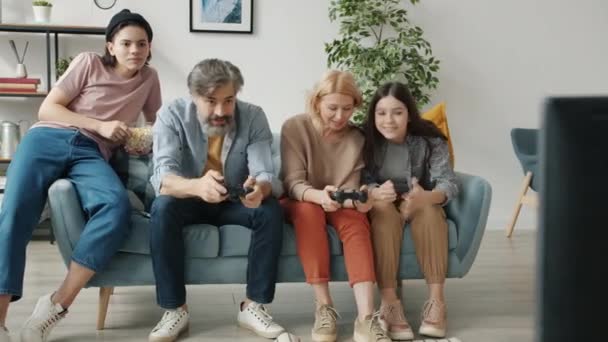 Szczęśliwa rodzina gra w gry wideo korzystających czas wolny razem wiążąc się z dziećmi — Wideo stockowe