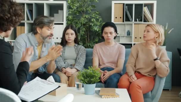 Проблемні сім'ї мати батько і підлітки діти розмовляють з психологом в офісі — стокове відео