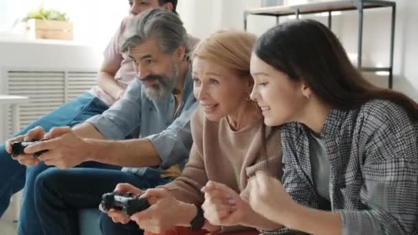 Homme et femme appréciant le jeu vidéo s'amuser avec des enfants adolescents dans l'appartement — Video