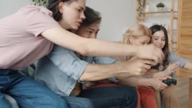 Anne ve baba video oyunu oynayıp evde eğlenen çocuklarla beşlik çakıyorlar.