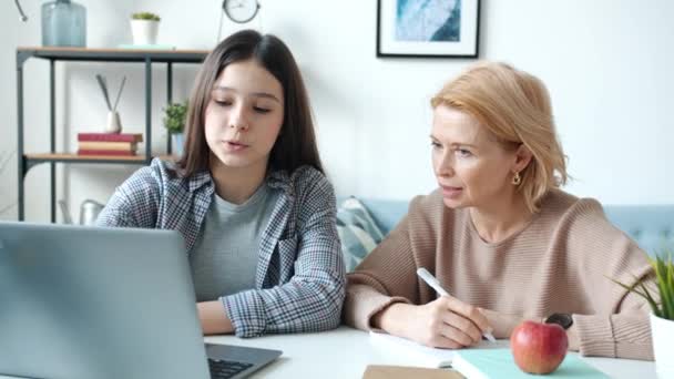 Adolescente chica usando laptop mientras madre escritura y hablando entonces haciendo high-five disfrutando de la educación en línea — Vídeos de Stock