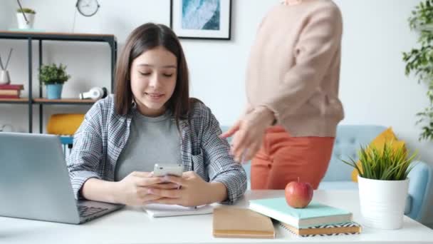 Líný teenager pomocí smartphonu místo toho, aby dělal domácí úkoly a pak být potrestán matkou — Stock video