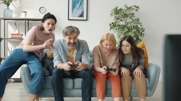 Rodzice grają w gry wideo, a nastolatki wiwatują w domu. — Wideo stockowe