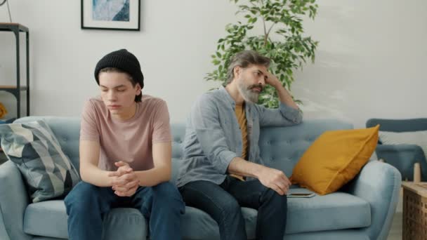 Portrait of unhappy father and kid sitting on couch in silence feeling sad and angry — Stock Video