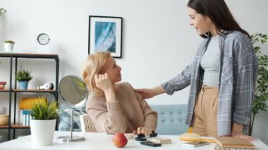 Olgun bir kadın aynaya bakıp kendini güzelleştiriyor sonra da genç kızıyla eğleniyor.