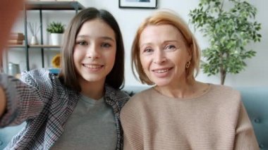 Anne ve kızının portresi kameraya bakıyor ve evdeki video konuşmalarıyla konuşuyor.