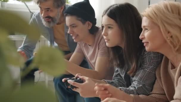 Movimento lento de crianças jogando videogame desfrutando de competição e abraçando os pais — Vídeo de Stock