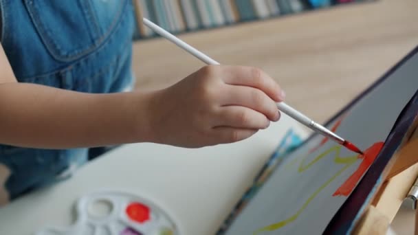 Primer plano de los niños pequeña mano con pintura al pincel cuadro en el interior del apartamento — Vídeos de Stock