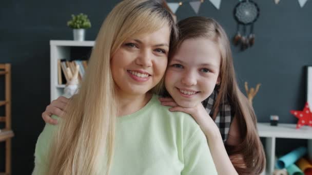 Porträt einer glücklichen Familienfrau und eines lächelnden Mädchens, die in die Kamera im Haus schauen — Stockvideo