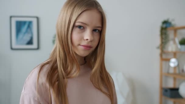 Slow motion porträtt av söt tonåring flicka som står hemma leende röra vid håret — Stockvideo