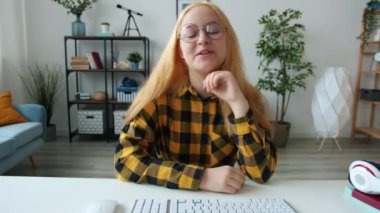 Neşeli gençler kameraya bakıp evdeki bilgisayarı kullanarak online arama yapıyorlar.