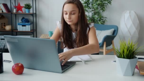 Tienermeisje studeren thuis werken met laptop en het maken van aantekeningen bezig met zelfstudie — Stockvideo
