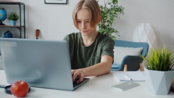 Повільний рух підлітка-підлітка з ноутбуком, а потім закриття комп'ютера відмовляється від залишити кімнату — стокове відео