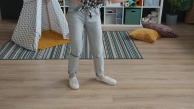 Evde, kulaklık takmış, müzik dinleyen neşeli çocukların ağır çekimleri.