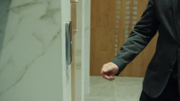 Медленное движение крупным планом людей вручную нажав кнопку лифта в бизнес-центре — стоковое видео