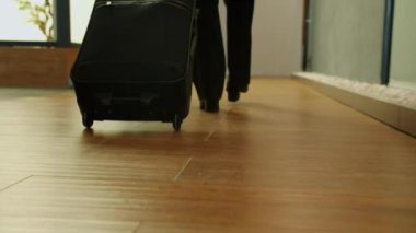 Otel lobisinde bavulla yürüyen kadın bacakları yavaş çekimde.