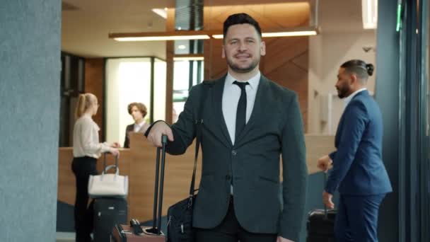 Zeitlupenporträt eines gutaussehenden Geschäftsmannes mittleren Alters im Anzug, der in der Hotellobby steht — Stockvideo