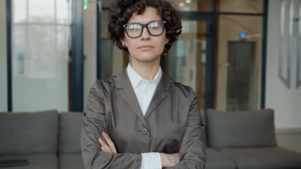 Zeitlupenporträt einer attraktiven jungen Geschäftsfrau, die mit ernstem Gesicht in der Lobby steht — Stockvideo