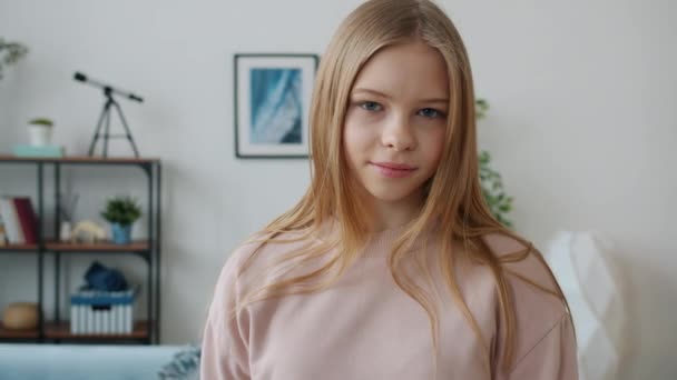 Портрет привабливої дівчини-підлітка, що показує жест нормальної руки, посміхаючись дивитися на камеру вдома — стокове відео