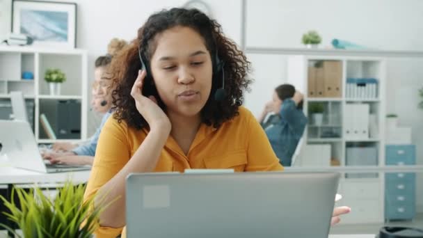 Amichevole giovane donna afro-americana che chiama parlando con il cliente nel servizio clienti — Video Stock