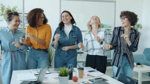 Ritratto al rallentatore di donne felici diverse ballando e cantando di gruppo divertendosi in ufficio — Video Stock