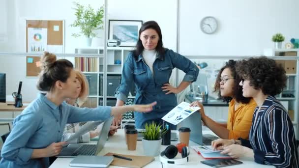 Diverso gruppo di donne brainstorming guardando grafici che discutono di affari in ufficio — Video Stock