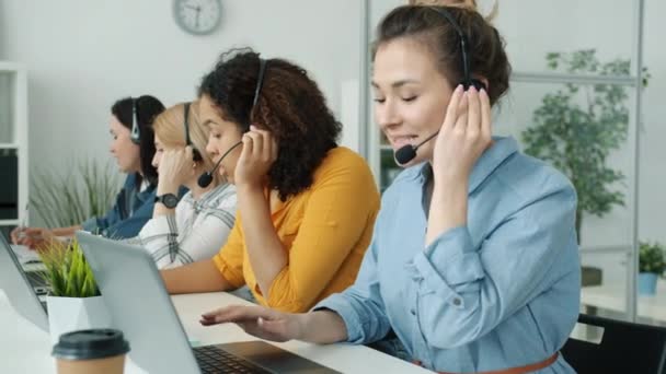 Grupo multiétnico de empleados que trabajan en el centro de llamadas hablando con los clientes que escriben con el ordenador portátil — Vídeo de stock
