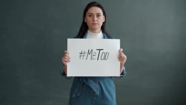 Zpomalený portrét ženy držící MeToo hashtag banner a dívající se na kameru stojící osamoceně — Stock video