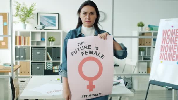 Retrato em câmera lenta da mulher adulta feminista segurando cartaz no escritório feminista sozinho — Vídeo de Stock