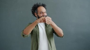 Arkadaş canlısı melez ırkın portresi cep telefonu el hareketi yapıyor ve telefon numarası veriyor.
