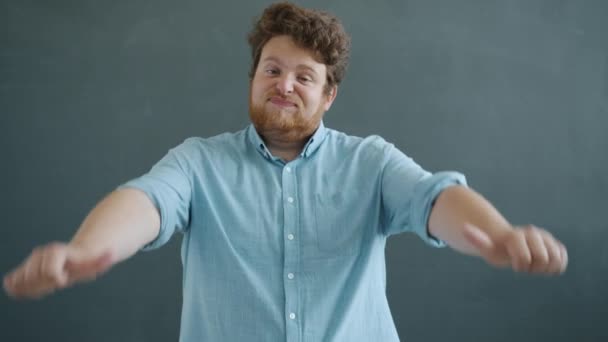 Retrato de tipo decepcionado mostrando el gesto de la mano hacia abajo pulgares y sacudiendo la cabeza sobre fondo gris — Vídeos de Stock