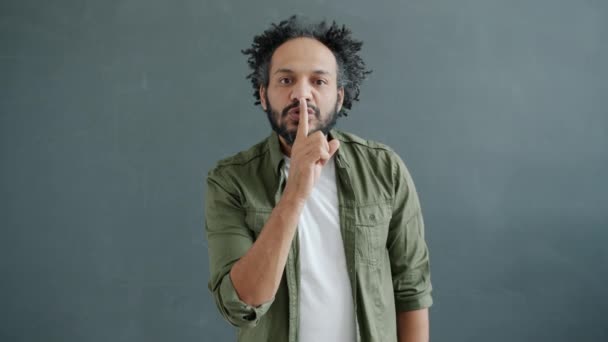 Retrato en cámara lenta del guapo árabe mostrando un gesto de la mano callada mirando a la cámara — Vídeo de stock