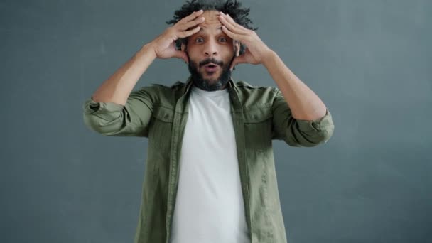 Porträtt av upphetsad arabisk man höja nävar fira framgång på grå bakgrund — Stockvideo
