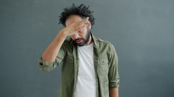 Homem árabe confuso e cansado tocando cabeça e rolando olhos que sofrem de dor de cabeça e estresse — Vídeo de Stock
