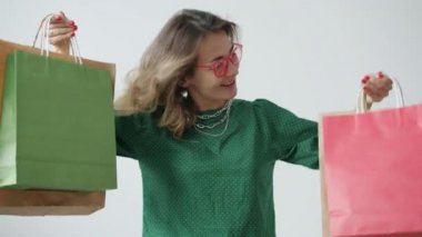 Aşırı neşeli alışveriş torbalarının ve gülümsemenin ağır çekimde portresi.