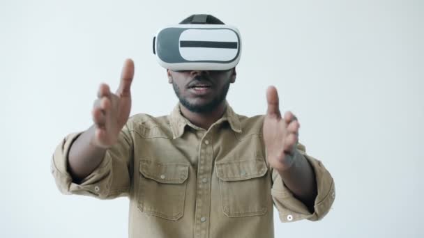 Mouvement lent de l'homme afro-américain joyeux appréciant les lunettes de réalité virtuelle activité bras mobiles — Video