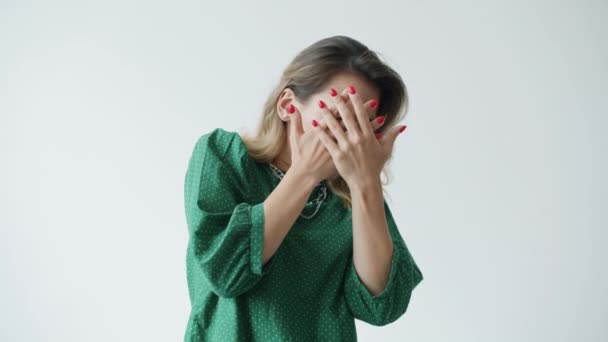 Portret van een mooie jonge vrouw die het gezicht bedekt met handen die angst en shock uitdrukken — Stockvideo